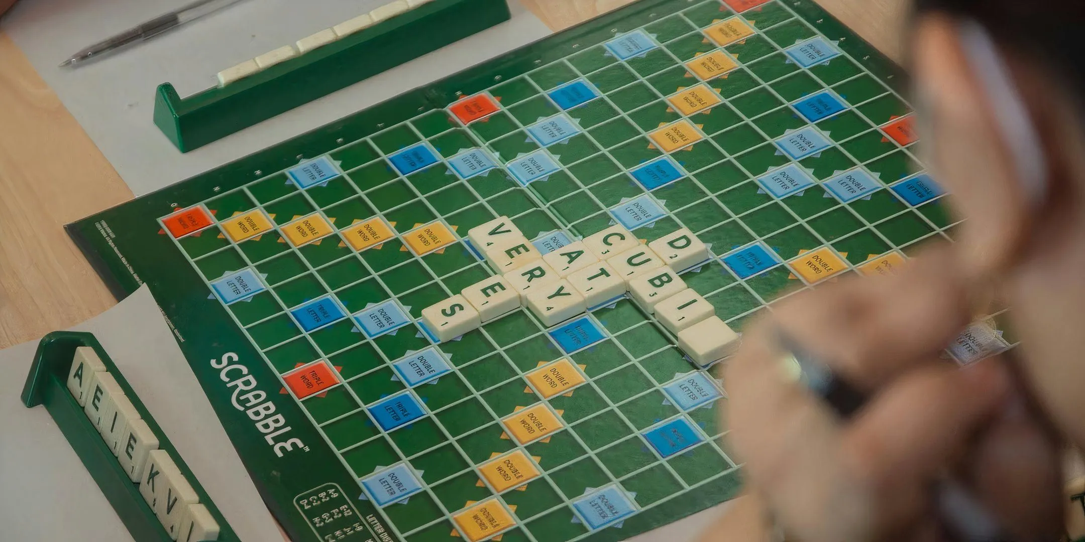 Bàn cờ Scrabble với các quân chữ cái được xếp trên bảng, biểu tượng của sự tập trung và tư duy ngôn ngữ trong board game.