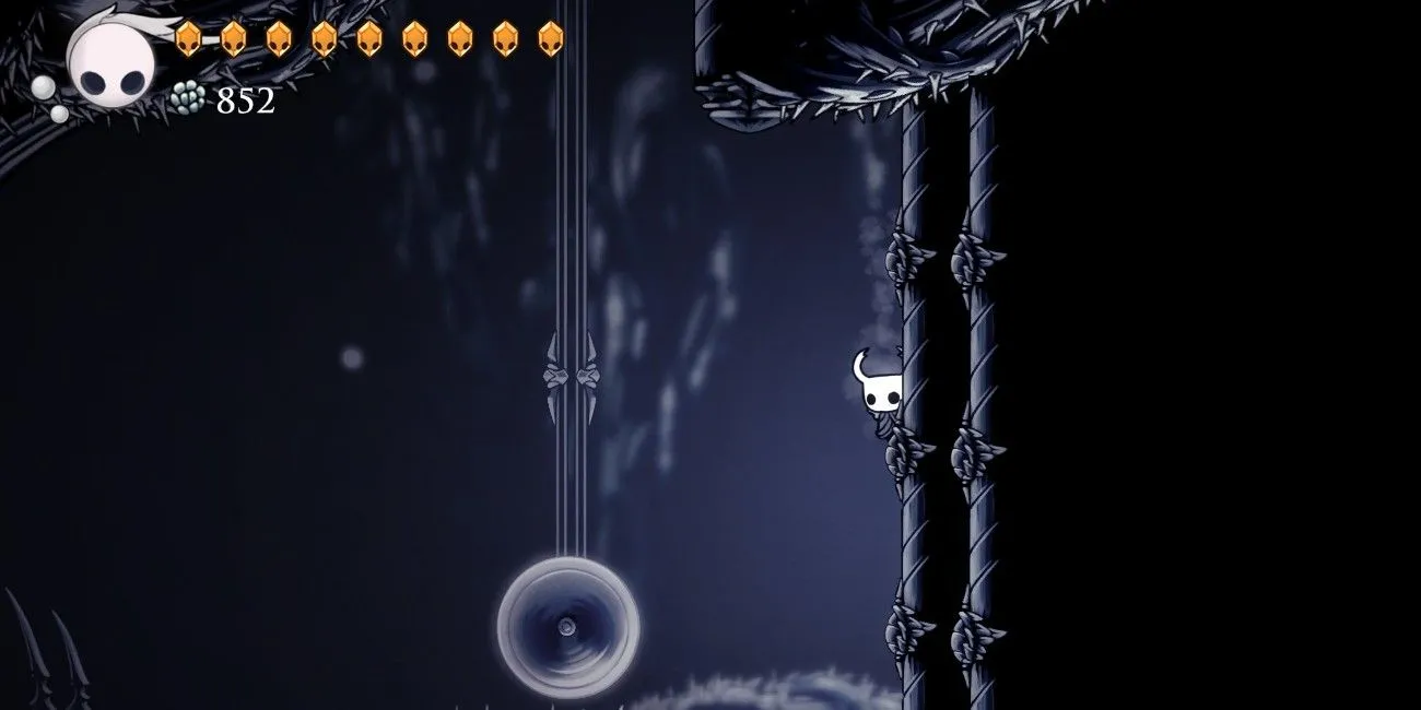 Nhân vật Hollow Knight bám tường trong một phân đoạn của Path of Pain